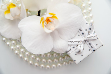 Obraz na płótnie Canvas Gift box and white orchid on a white background 