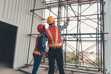 Fototapeta premium Construction engineer teamwork are inspection site constructing and installation steel scaffolding platform., Project manager and architect are looking and pointing to problem of structure steel.