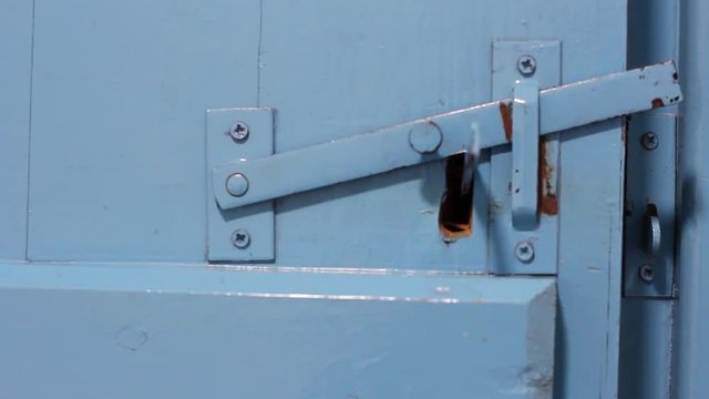 Antique metal bolt opens from the inside and the old wooden door opens.
