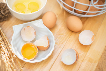 Fresh farm eggs on a wooden background. separated egg white and yolk. Eggs in bowl for cooking omelet.