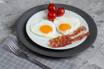 Tasty Fried Egg in the Shape of a Heart Served on a White Plate with Bacon Tomato Basil Pepper Gray Background Valentine Day Morning