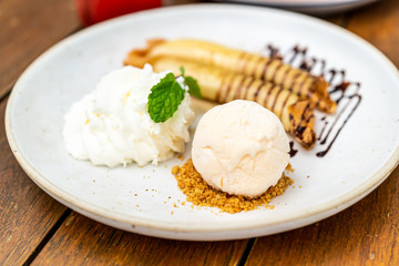 vanilla ice-cream with banana crape and whipped cream