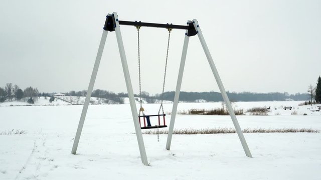 Empty swing  in winter time with snow 4K