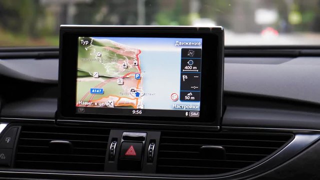 Close-up shot of car driving with GPS. On the screen written: Movement, setting, navigation to the target, tour, resort prospect, Novorossiyskoe shosse street, Doroga na Bolshoi Akhun