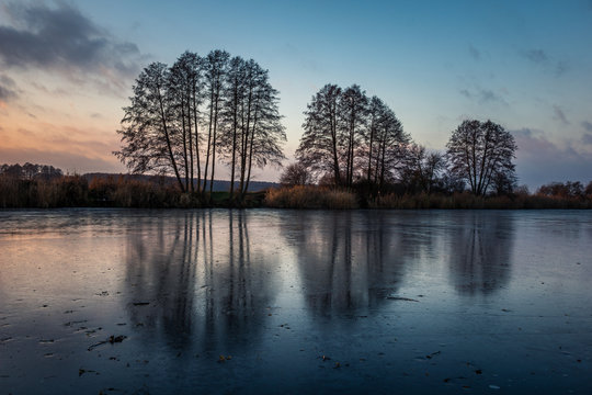 Autumnal landscape with trees and their reflection in the lake during the setting sun near Konstancin-Jezorna, Masovia, Poland