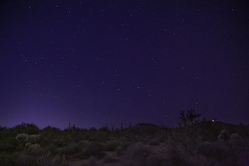 Fototapeta premium The desert at night shows starry skies and wilderness landscape east of Phoenix, Arizona. Light pollution is making shooting these night scapes more difficult to find dark skies without city glare