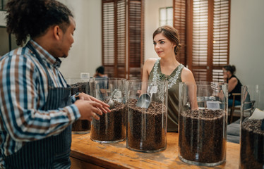 Coffee bean connoisseur sharing information of the types of coffee beans to a potential customer