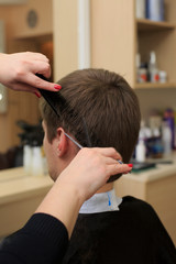 Man having a haircut from hairdresser. Close-up picture of shaving a mans head