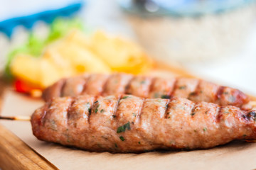 Fried minced meat - traditional Greek lunch on a blue plate in a restaurant.