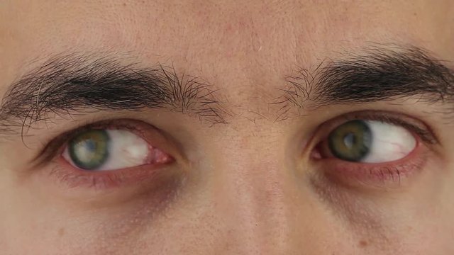 man eyes moves from side to side, reading from upper to center, close-up