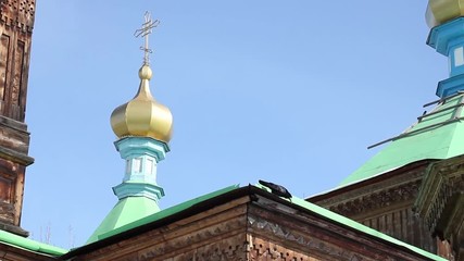 roof with dome of wooden Orthodox Holy Trinity Cathedral in Karakol, black bird drinking, winter, Kyrgyzstan, 2015 - Powered by Adobe