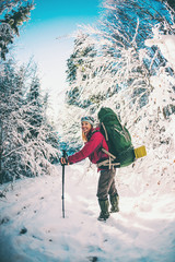 Woman with backpack and snowshoes in the winter mountains.