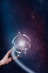 Human forefinger touches atom. Nebula dust  in infinite space. Mixed media.