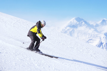 Fototapeta na wymiar Alpine skier on piste running downhill