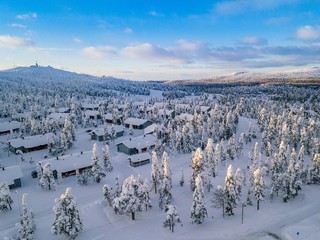 Aerial view of snow covered winter forest and road. Beautiful rural landscape in Finland