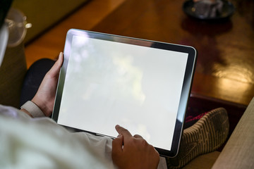 Girl working with tablet while sitting sofa