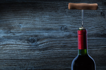 top view on bottle of red wine and corckscrew.