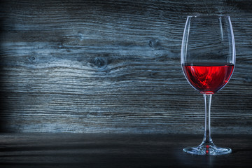 halfline wineglass with red wine on vintage wood.