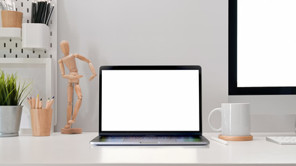 Modern office workplace with blank screen tablet mockup, pc and stylish supplies on the office desk.