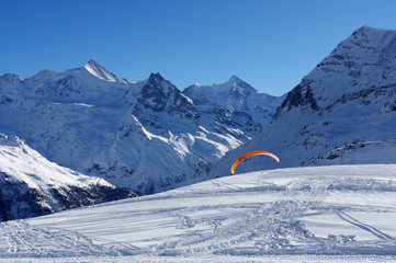Parapente disparaissant derri&egrave;re une piste de ski
