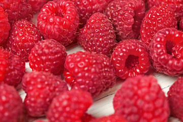 Close up of raspberries scattered on white boards.