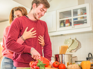 Young happy couple cooking healthy food in the kitchen