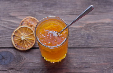 orange jam on wooden background, top view