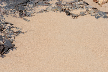 stone, rocks frame on beach sand background.
