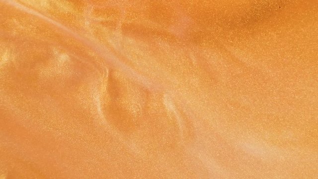 Colorful golden sand organically moves in colorful liquid