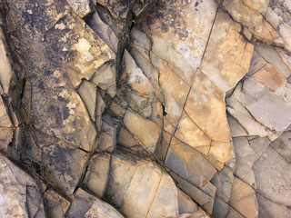 fractured rock strata as a background, cracked rock, stone texture, many cracks in the stone,...