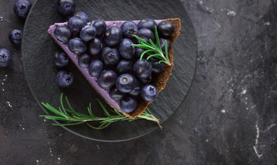 Blueberry vegan cheesecake. Dark photo on black background