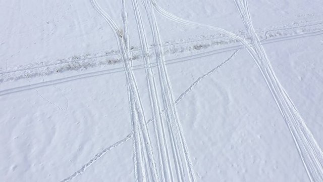 Ascending over trails in snow 4K drone footage