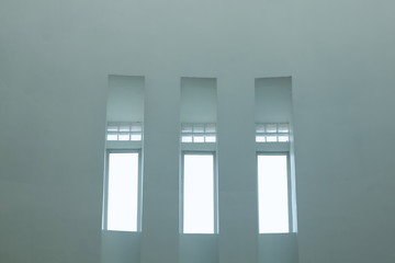 three similar window on the wall and bright shine .