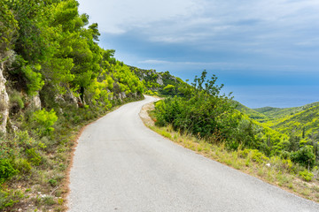 Greece, Zakynthos, Twisting mountain road along green paradise like nature landscape to the coast