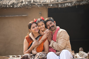 Indian family sitting on traditional bed in village