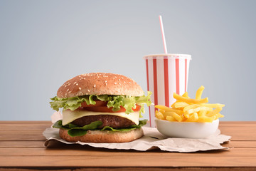 Beef burger on table with soda and chips gray backgorund
