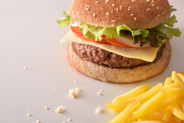 Burger with chips on white table elevated view