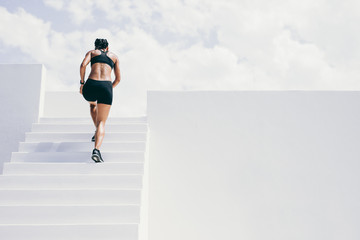 Fitness woman running up the stairs of a building