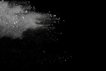 White powder explosion isolated on black background.