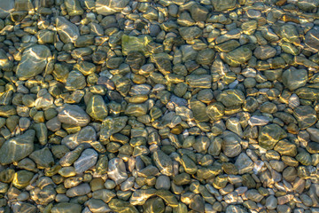 Sea stones background and light from the sun on the stones. Abstract art for background . Sun glare...