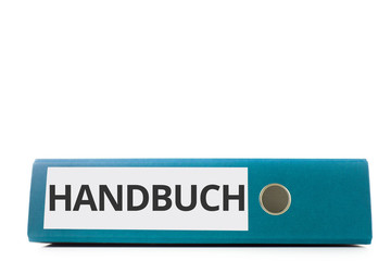 blauer liegender Aktenordner mit Beschriftung Handbuch vor hellem Hintergrund