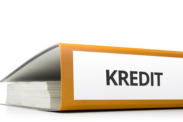 oranger Aktenordner gefüllt mit Papierseiten und Beschriftung Kredit liegend vor weißem...