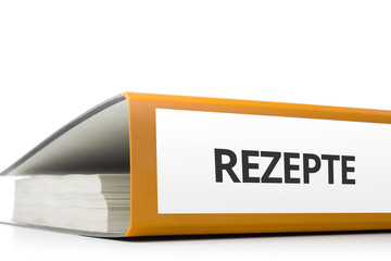 oranger Aktenordner gefüllt mit Papierseiten und Beschriftung Rezepte liegend vor weißem...