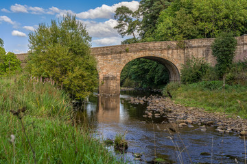 Fototapeta na wymiar Stone bridge over the River Derwent in Blanchland, Northumberland, England, UK