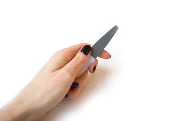 female hand with nail file.  young female hand with black manicure holding a nail file. manicure concept. place for text. manicure banner