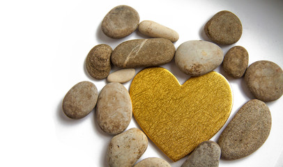 Fototapeta na wymiar golden heart and stones on a white background