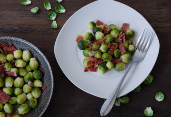Brussels sprouts with ham on dark background. Top view.