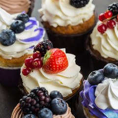 Various sweet cupcakes on brown stone background. 