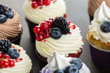Various sweet cupcakes on brown stone background. 