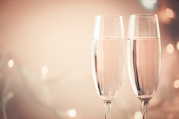 Champagne glasses on golden bokeh celebration background